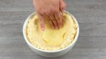 Ele coloca 10 fatias de queijo na tigela e despeja o risoto sobre elas. Isso vai ficar delicioso!