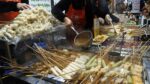 Comendo bolo de peixe, bolo de peixe picante, espetos de sundae na fila – Seomun Market / lanche de rua popular, bolo de peixe – comida de rua coreana